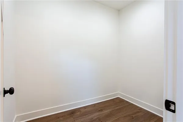 a view of a small space with wooden floor and a window