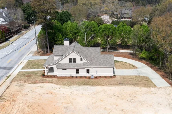 an aerial view of a house with swimming pool and trees