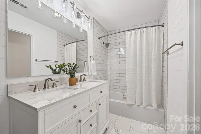 a bathroom with a granite countertop sink a mirror and a shower