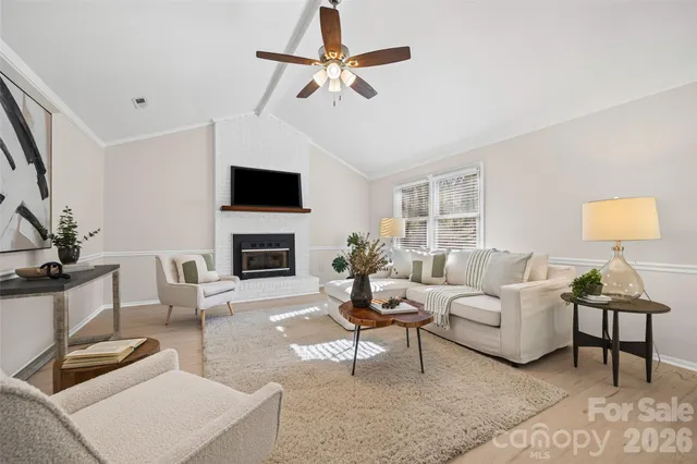 a living room with furniture a fireplace and a flat screen tv