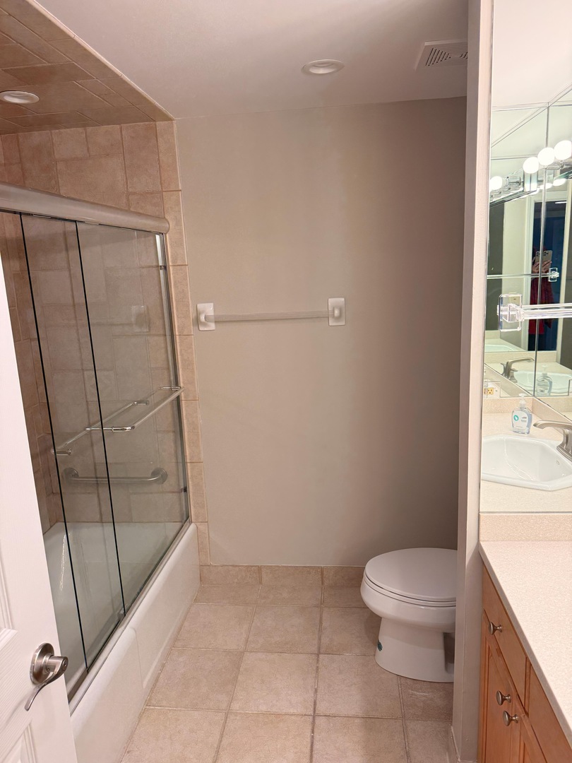 2066 St Johns Avenue, Unit 304 Highland Park, IL 60035 - Photo 13 of 18 a bathroom with a granite countertop sink a toilet a mirror and shower