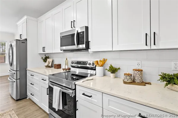 a kitchen with stainless steel appliances white cabinets and a stove