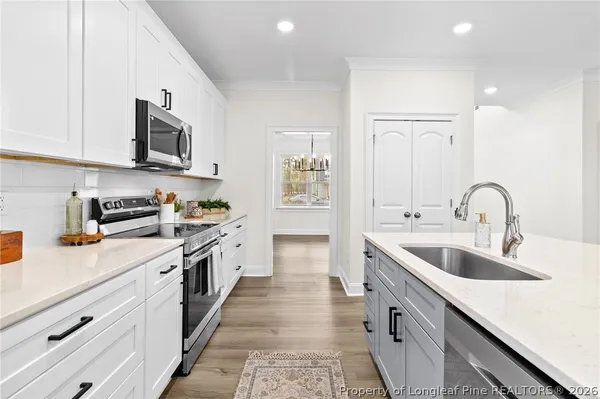 a kitchen with stainless steel appliances granite countertop a sink and dishwasher a stove top oven with wooden floor