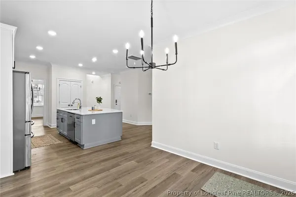 a kitchen with stainless steel appliances granite countertop a sink a refrigerator and wooden floor