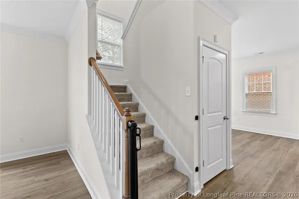 a view of a hallway with wooden floor and entryway