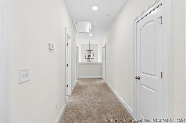 a view of a hallway with wooden floor and closet area