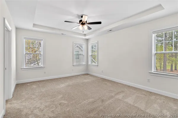 an empty room with windows and fan