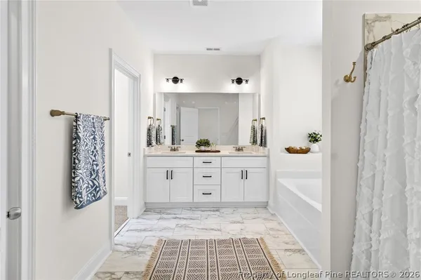 a spacious bathroom with a shower sink and mirror