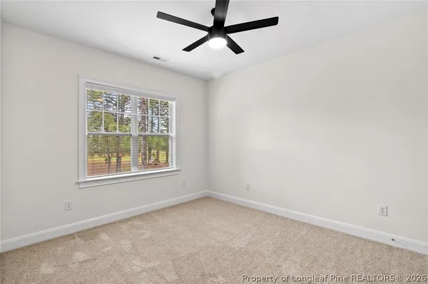 an empty room with a window and a fan