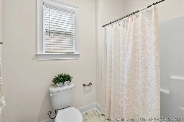 a white toilet sitting next to a shower curtain