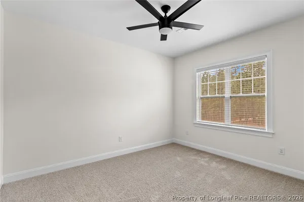 an empty room with a window and a fan