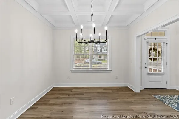a view of empty room with wooden floor and window