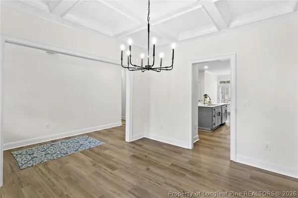 a view of a room with wooden floor and a ceiling fan