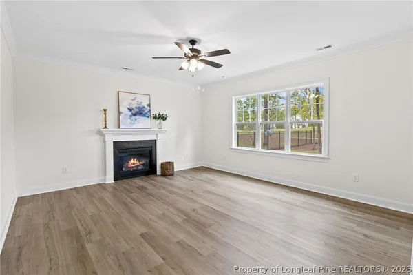 an empty room with windows and fireplace