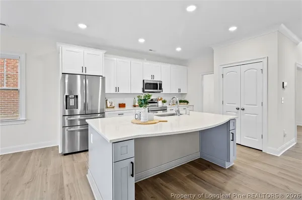 a kitchen with a sink stainless steel appliances and white cabinets