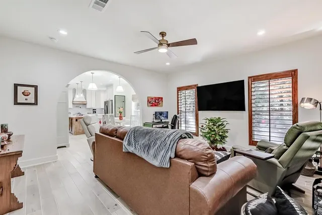 a living room with furniture a large window and a flat screen tv
