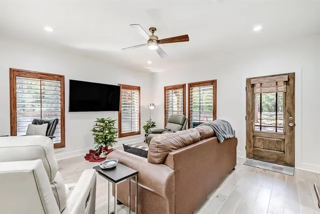 a living room with furniture a flat screen tv and a large window