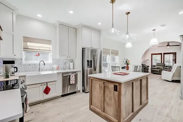 a kitchen that has a lot of cabinets and wooden floor
