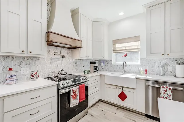 a kitchen with stainless steel appliances granite countertop a sink stove and cabinets