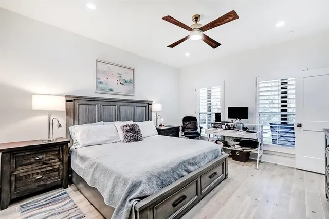 a bedroom with a bed a dresser and a chandelier