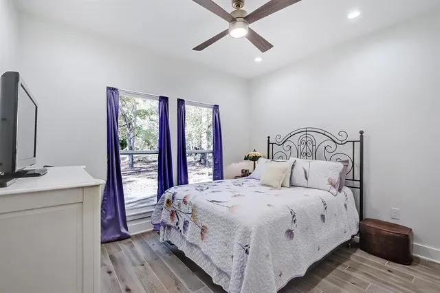 a bedroom with a large bed and a flat tv screen on dresser
