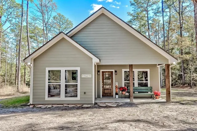 a view of a house with a yard and large tree