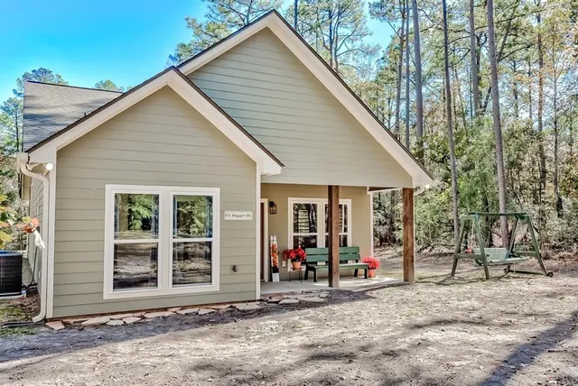 a view of a house with a patio and a yard