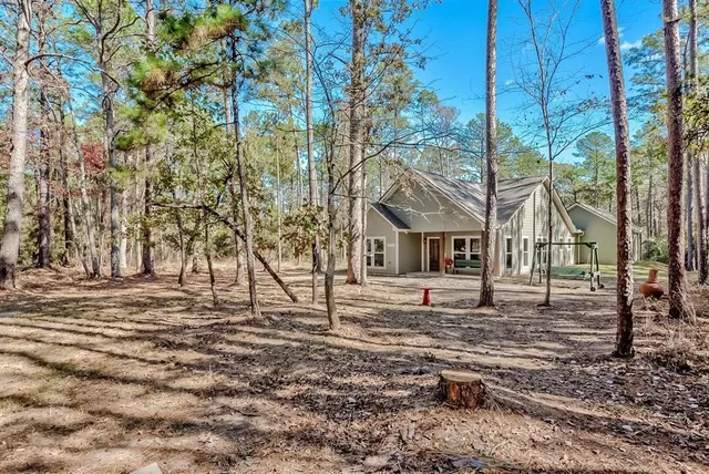 a view of house with yard and trees