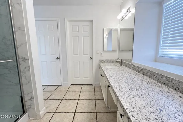 a bathroom with a granite countertop sink and a mirror