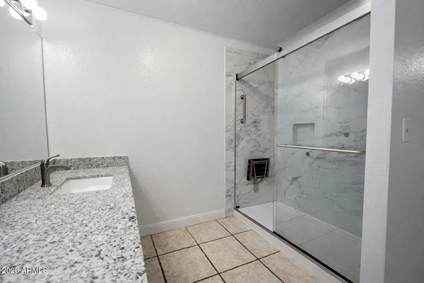 a bathroom with a granite countertop sink a toilet and shower