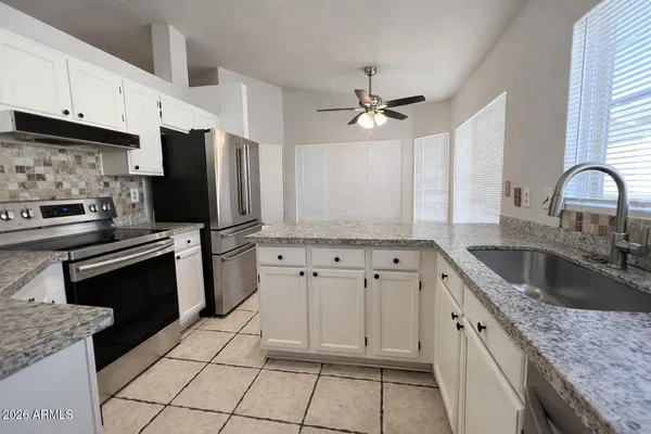 a kitchen with granite countertop a sink stainless steel appliances and cabinets