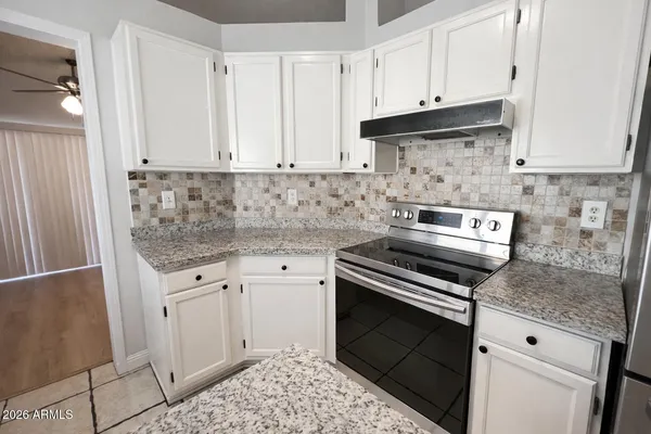 a kitchen with granite countertop a stove sink and cabinets