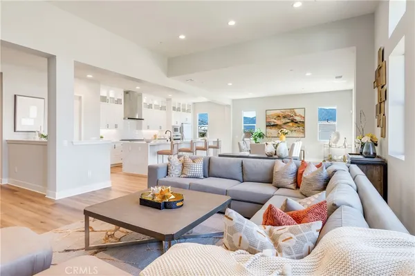 a kitchen with stainless steel appliances granite countertop a stove top oven a sink dishwasher and a dining table with wooden floor