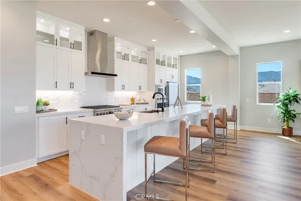 a large white kitchen with sink and wooden floor