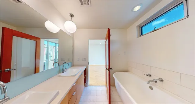 a bathroom with a tub sink and mirror