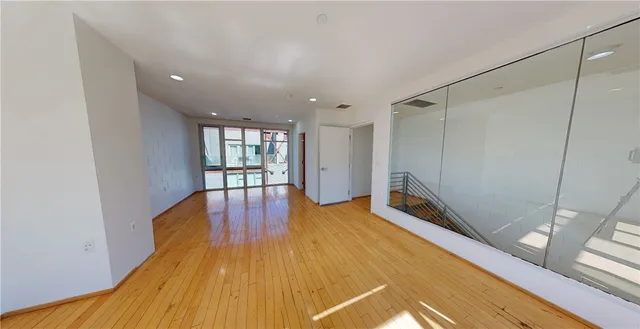 a spacious bedroom with a bed and wooden floor