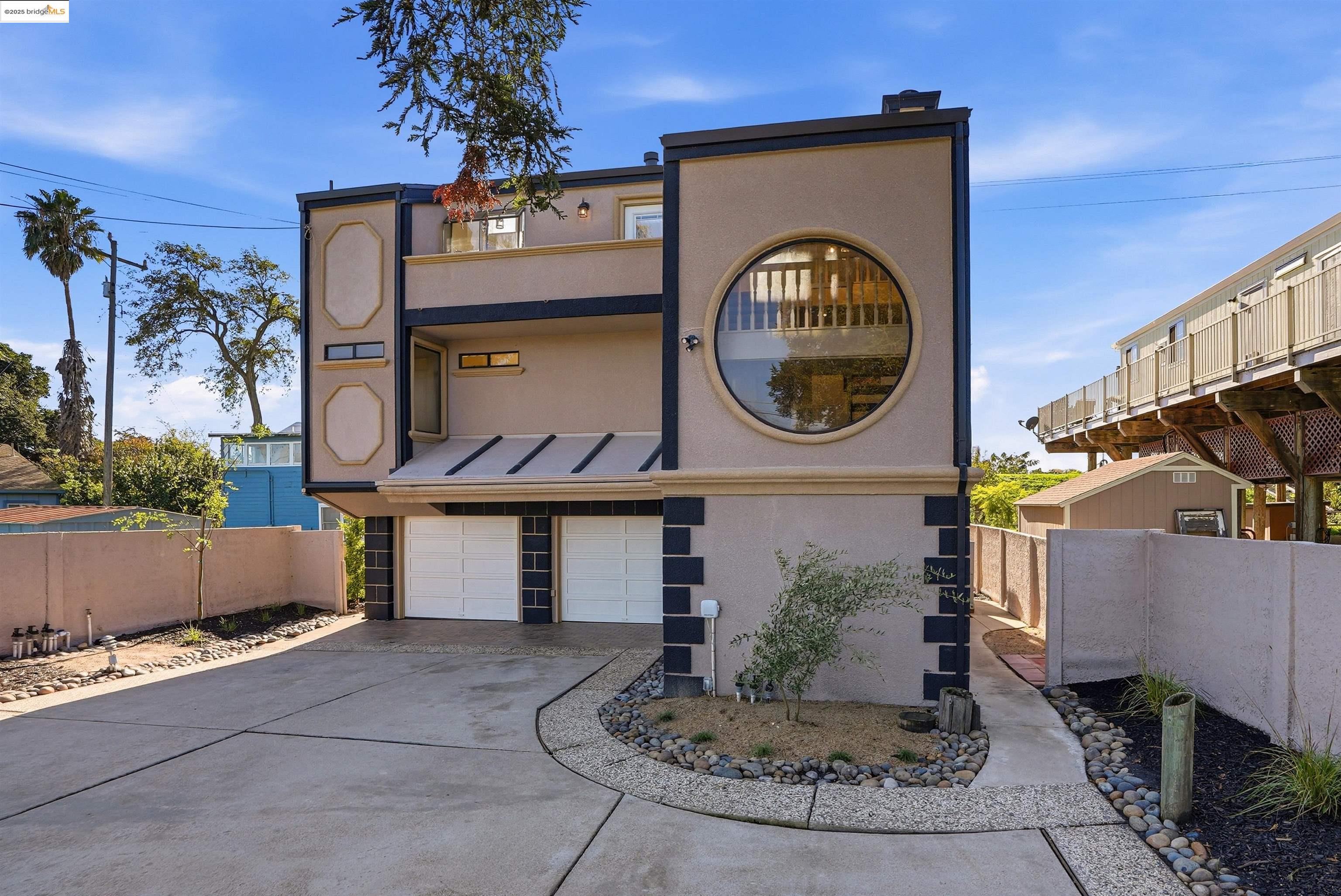 View of front of home with stucco siding, a garage, concrete driveway, a standing seam roof, and a metal roof