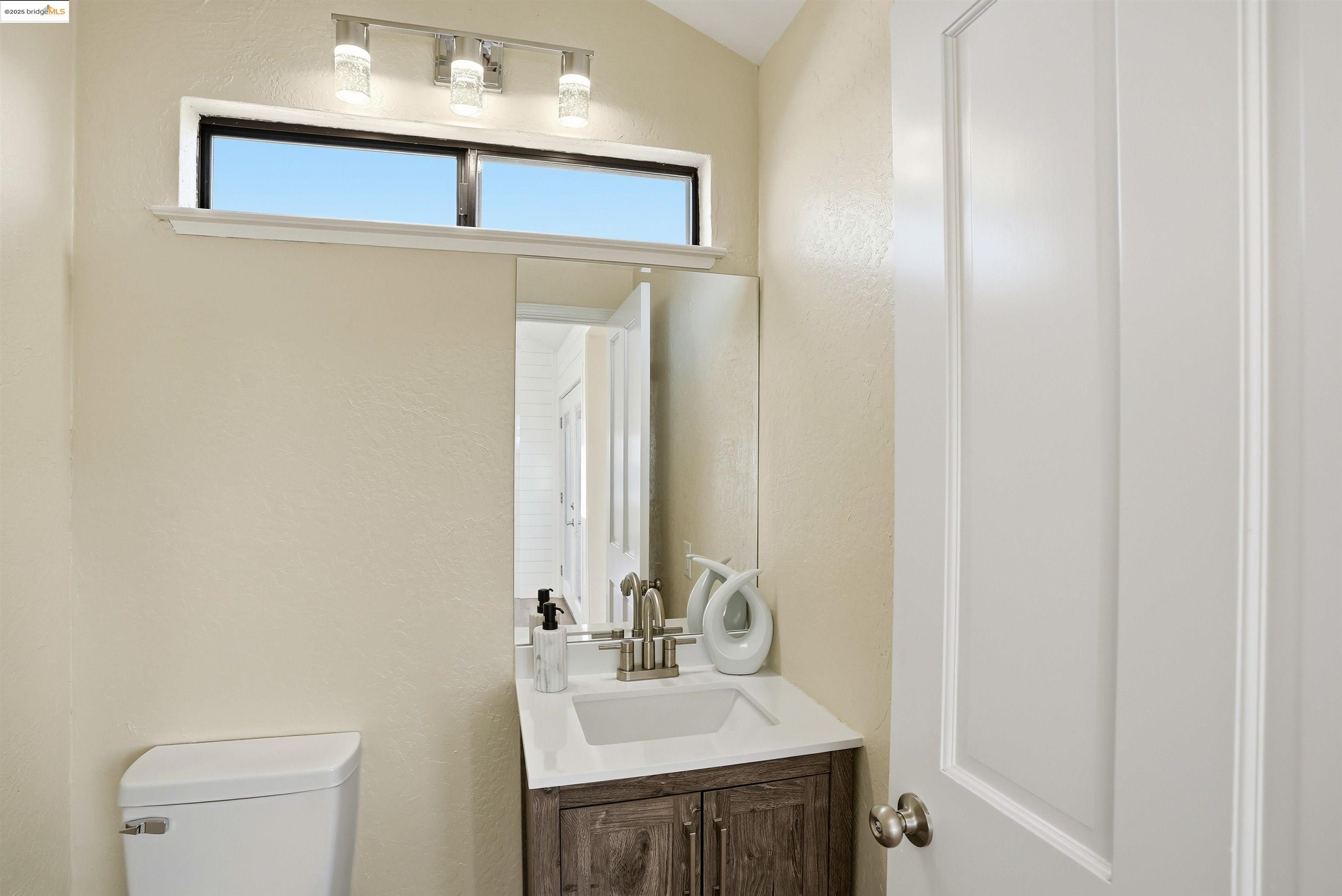 2796 Taylor Road Bethel Island, CA 94511 - Photo 16 of 49 Half bath featuring a textured wall, vanity, and vaulted ceiling