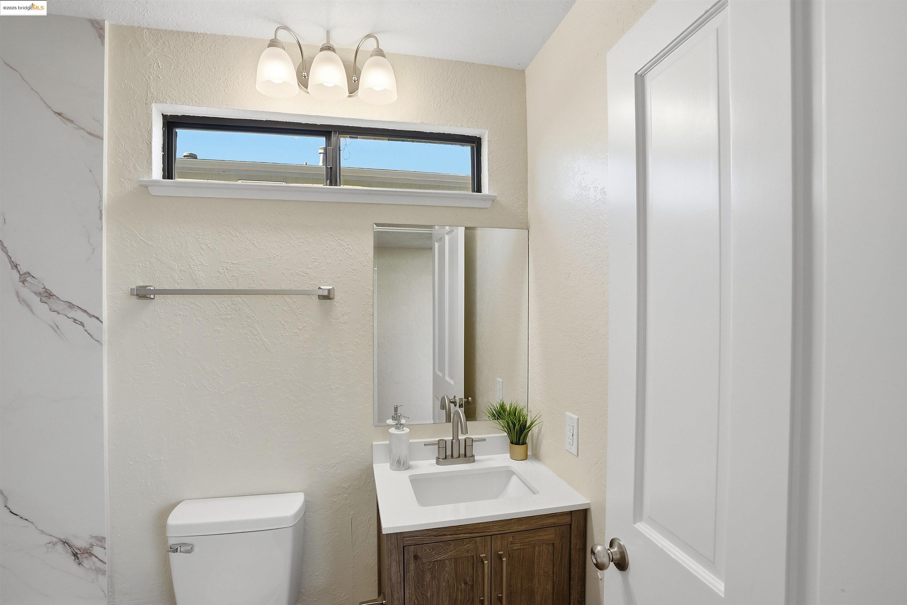 2796 Taylor Road Bethel Island, CA 94511 - Photo 17 of 49 Bathroom with a textured wall, vanity, and a chandelier