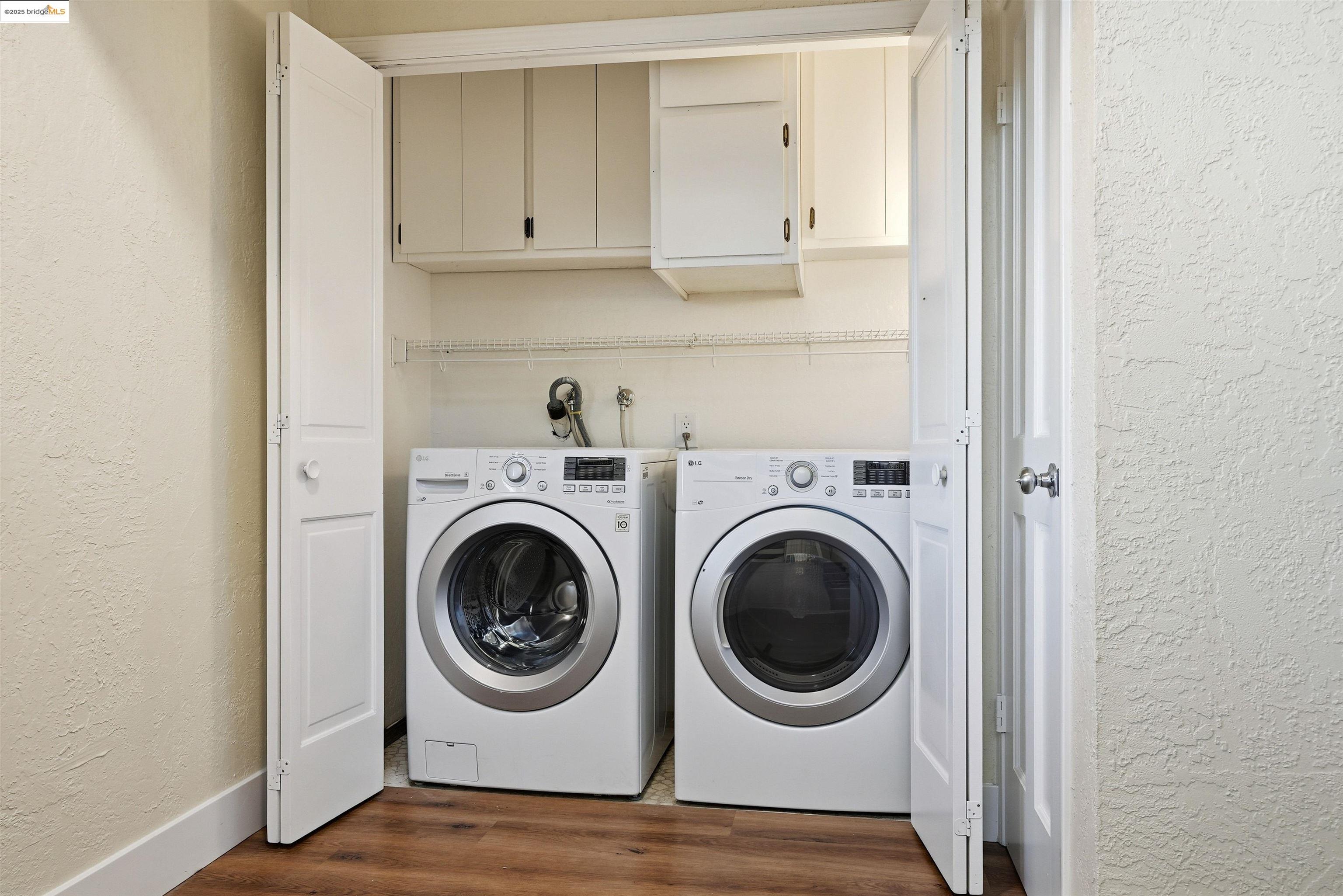 2796 Taylor Road Bethel Island, CA 94511 - Photo 31 of 49 Washroom featuring a textured wall, cabinet space, washer and dryer, and dark wood finished floors
