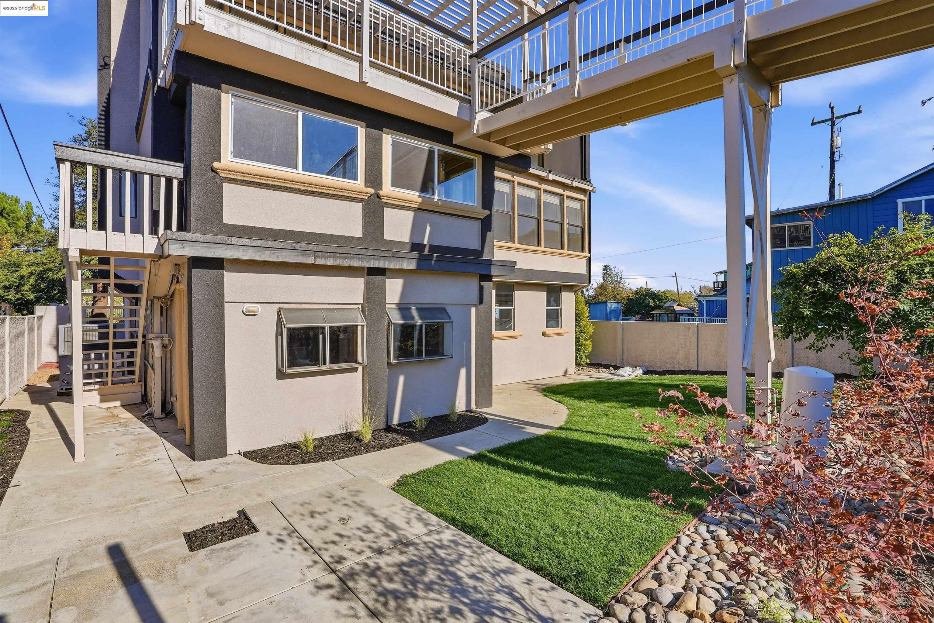 2796 Taylor Road Bethel Island, CA 94511 - Photo 41 of 49 Rear view of property featuring stucco siding, stairs, and a fenced backyard