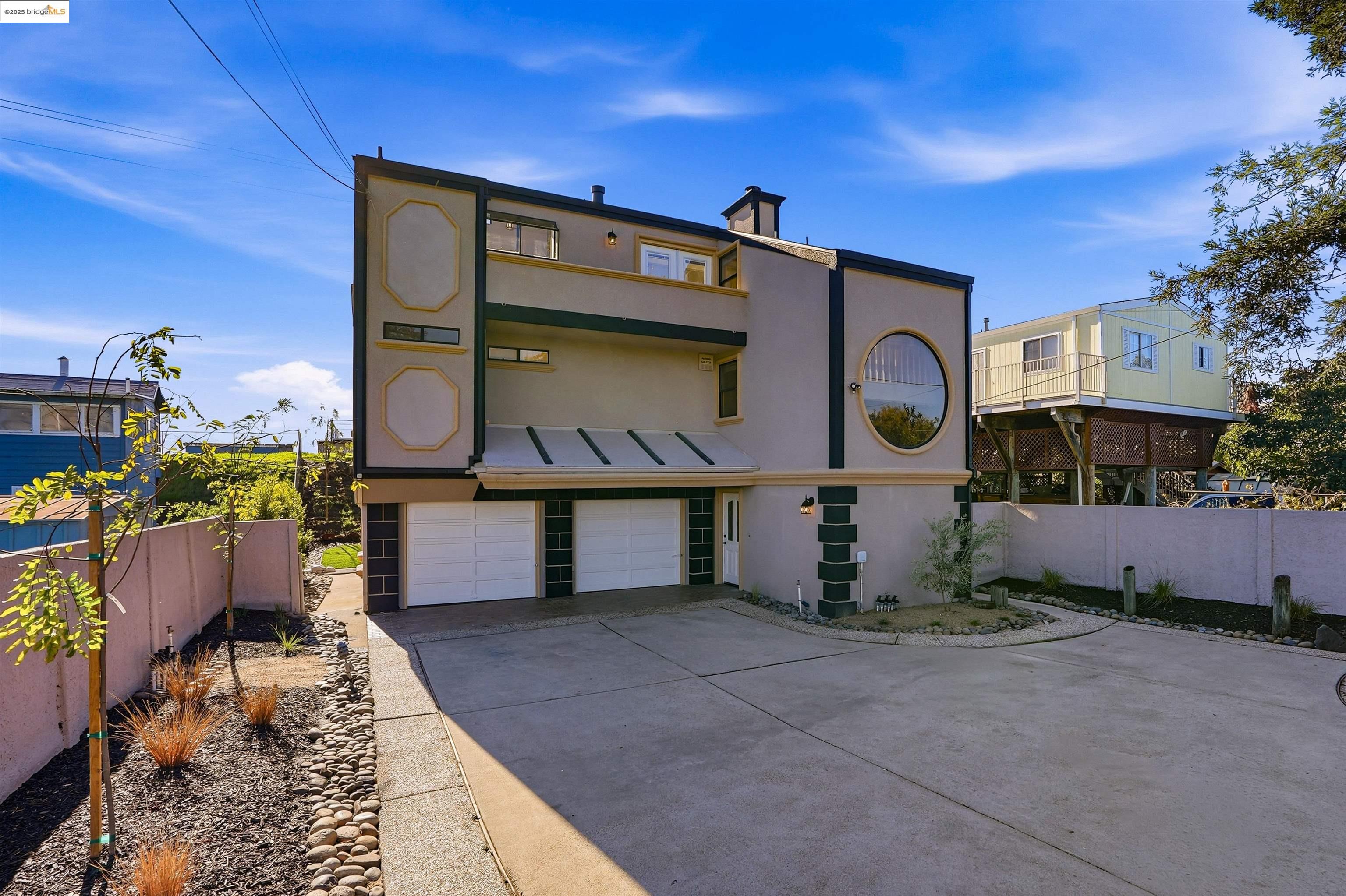 2796 Taylor Road Bethel Island, CA 94511 - Photo 49 of 49 Rear view of house featuring stucco siding, concrete driveway, a garage, a chimney, and a balcony