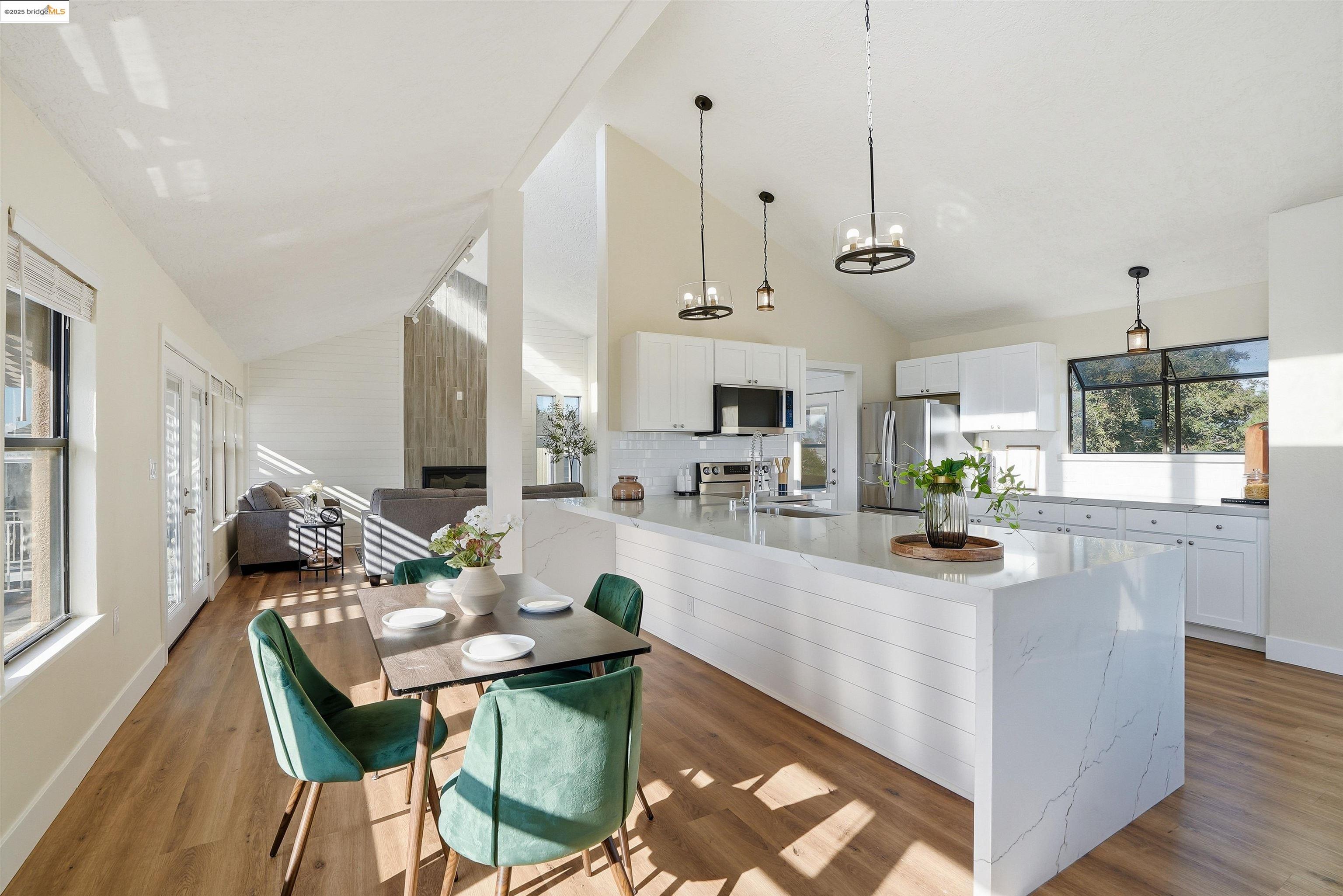 2796 Taylor Road Bethel Island, CA 94511 - Photo 10 of 49 Kitchen featuring white cabinets, light stone counters, hanging light fixtures, a peninsula, and high vaulted ceiling