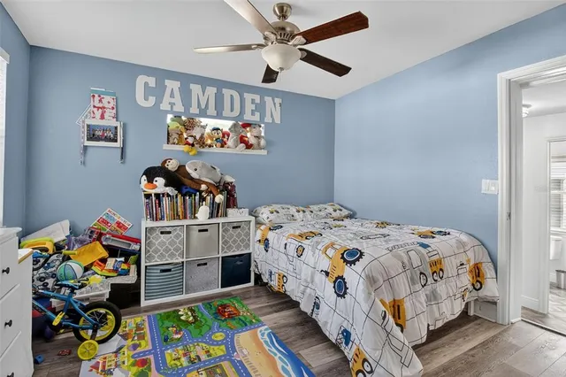 a bedroom with bed and wooden floor