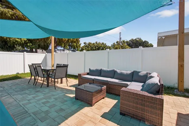 a view of a patio with a table and chairs under an umbrella
