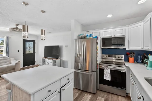 a kitchen with stainless steel appliances a stove microwave and refrigerator