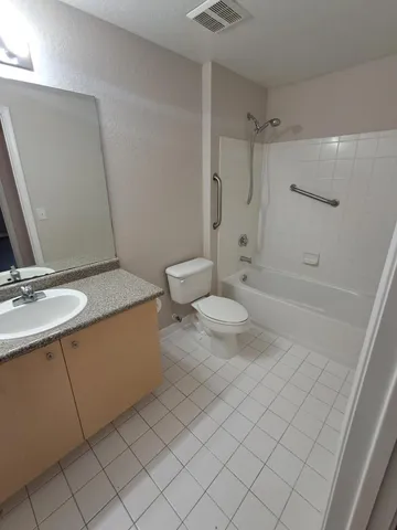 a bathroom with a granite countertop sink a toilet and shower
