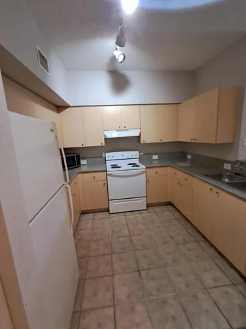 a kitchen with a stove top oven and cabinets