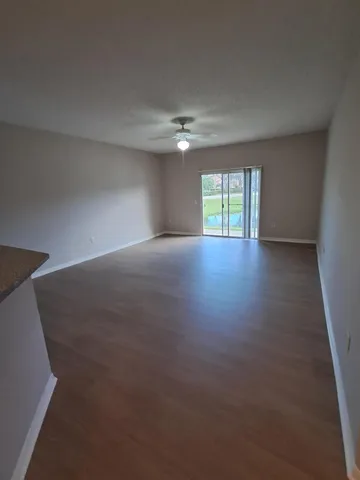 an empty room with windows and ceiling fan