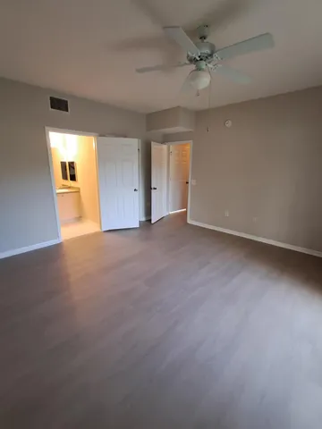 an empty room with a window and a ceiling fan